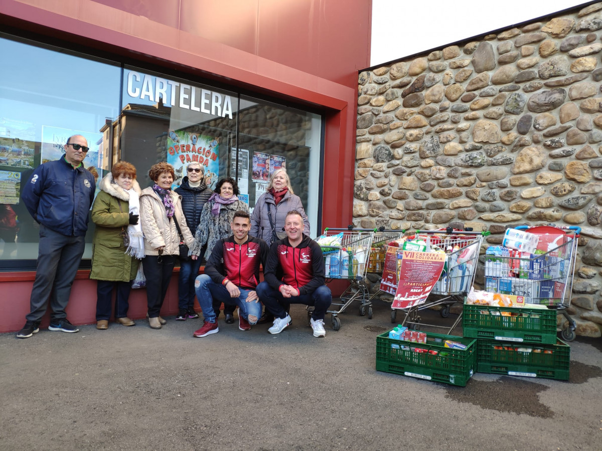 Entrega alimentos. Miembros de Caritas Parroquial y el Presidente y Vicepresidente del Club.