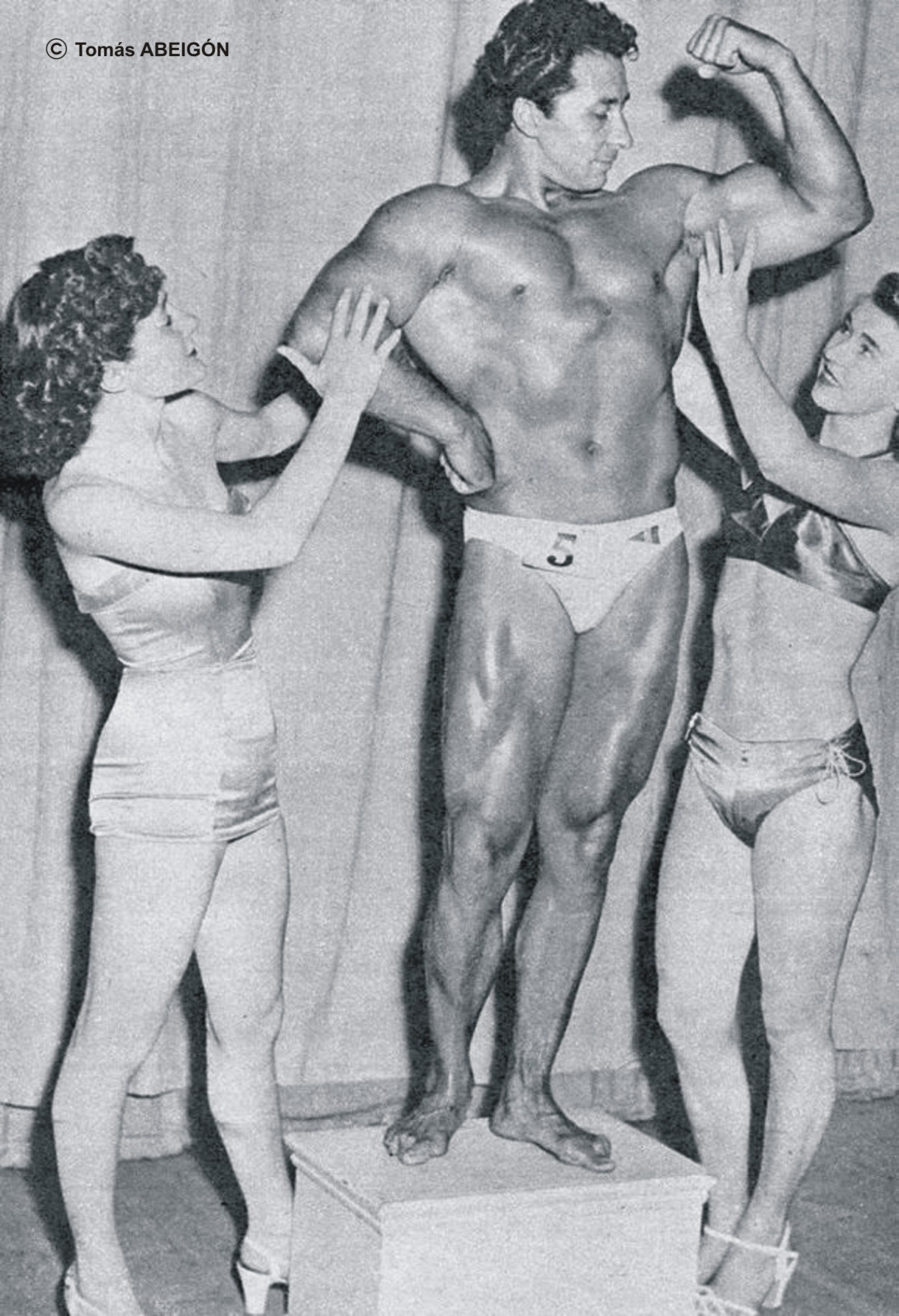 Juan FERRERO que despertu00f3 la admiraciu00f3n de estas dos bellas seu00f1oritas tras haberse proclamado vencedor del certamen de Mr. Universo Profesional NABBA en 1952